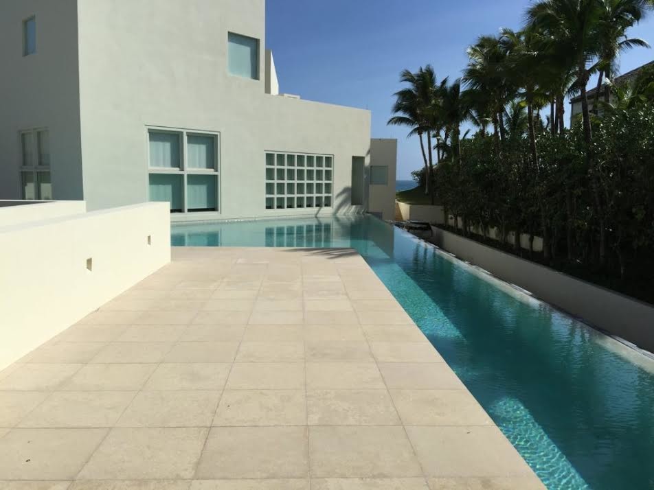 Imagen de piscina alargada contemporánea de tamaño medio a medida en patio trasero con adoquines de hormigón
