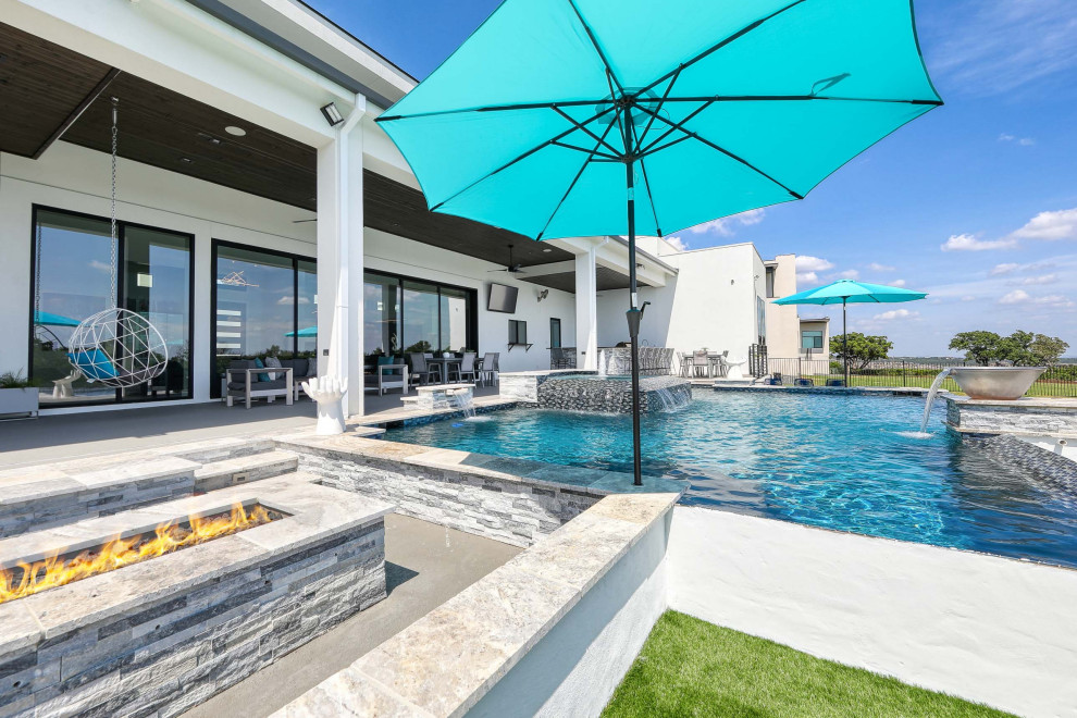 Foto di una grande piscina design personalizzata dietro casa con fontane