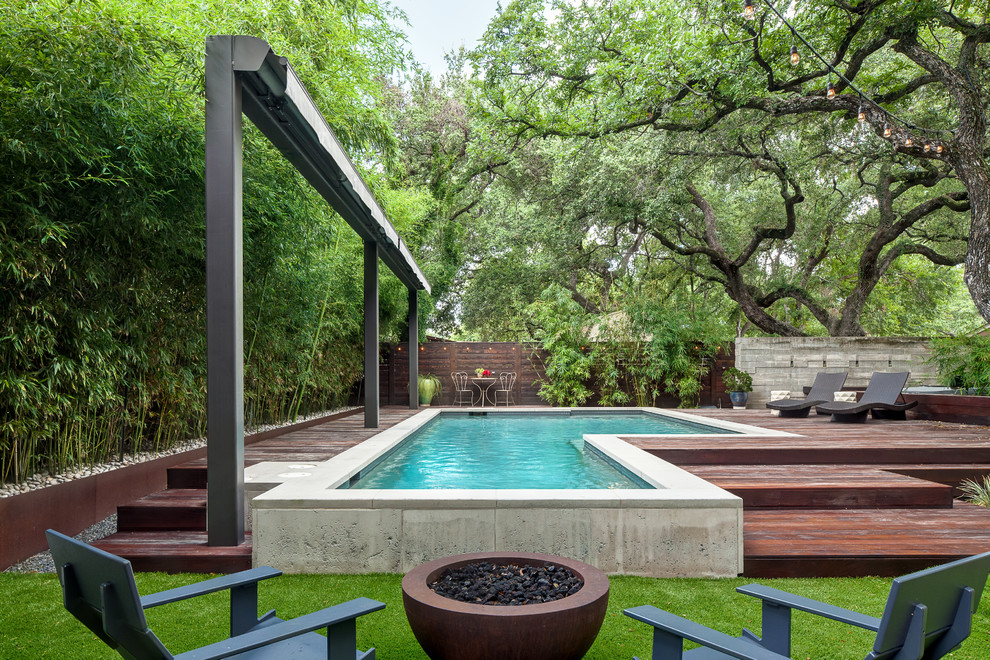 Ejemplo de piscina moderna de tamaño medio a medida en patio trasero con entablado