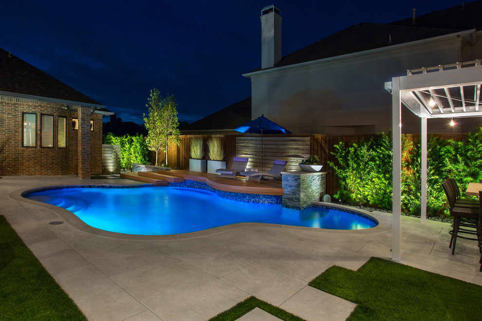 Mittelgroßer Klassischer Schwimmteich neben dem Haus in individueller Form mit Wasserspiel und Betonboden in Dallas