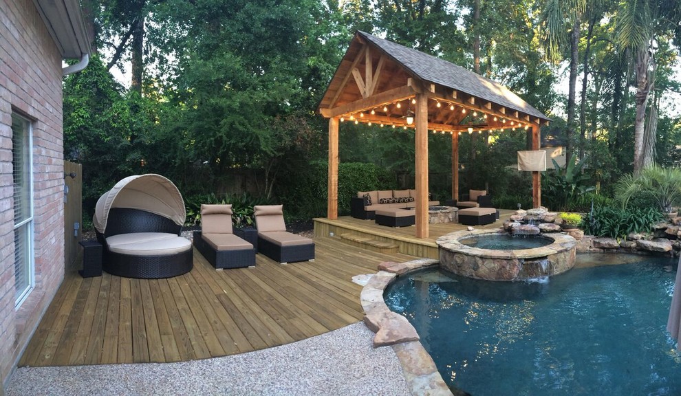 Diseño de piscinas y jacuzzis naturales tropicales de tamaño medio a medida en patio trasero con adoquines de piedra natural