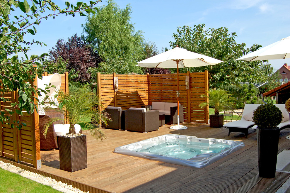 Inspiration pour une piscine hors-sol design rectangle avec un bain bouillonnant, une cour et une terrasse en bois.