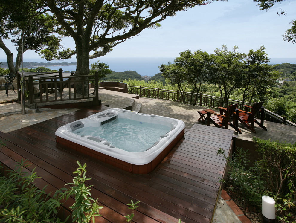 Idée de décoration pour une petite piscine arrière et hors-sol chalet rectangle avec un bain bouillonnant et une terrasse en bois.