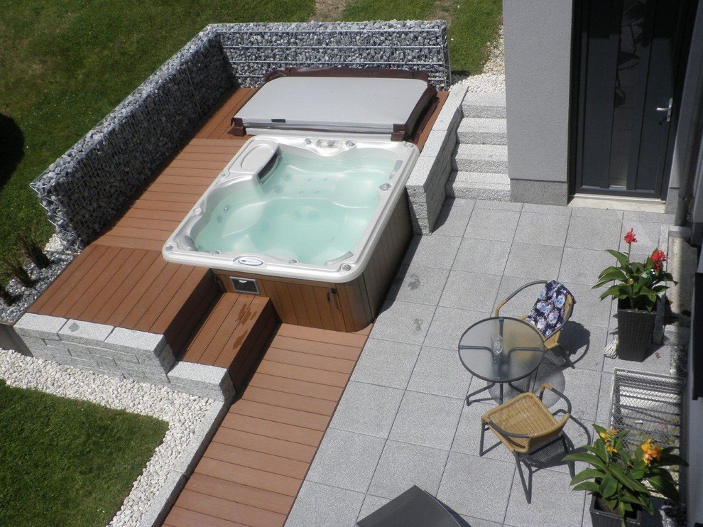 Ejemplo de piscinas y jacuzzis elevados contemporáneos rectangulares en patio con entablado
