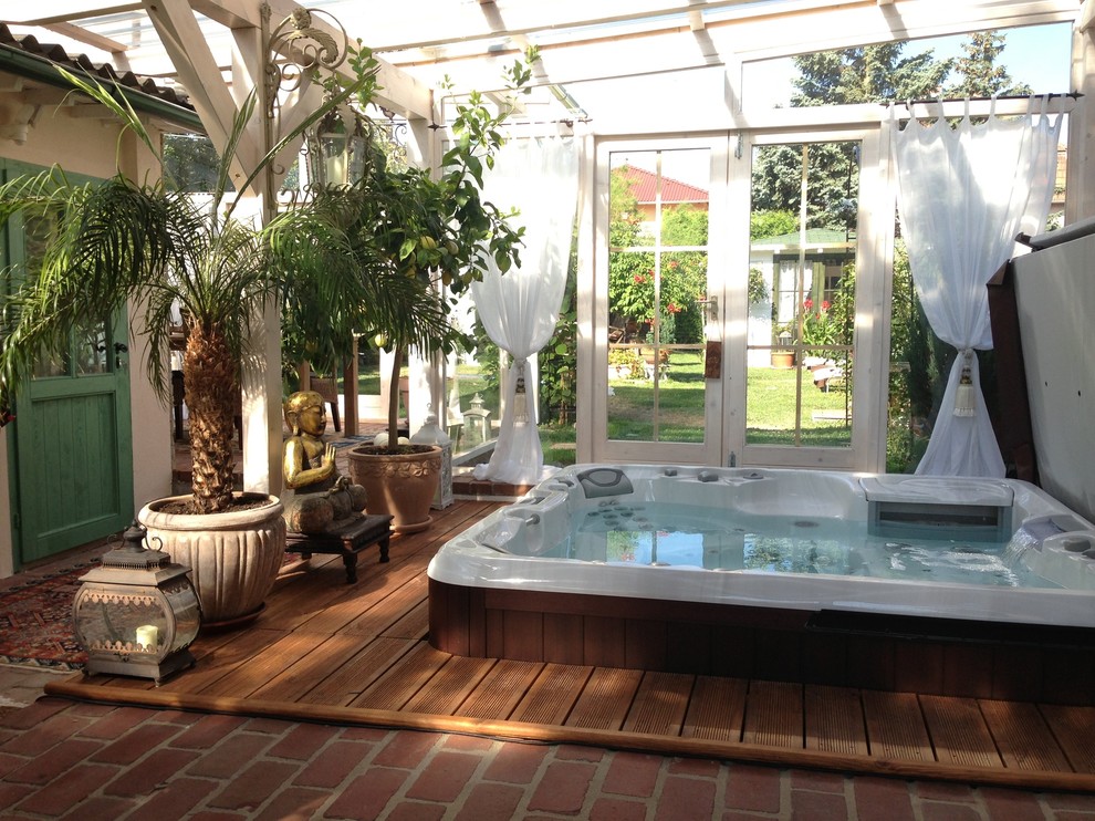 Aménagement d'une petite piscine hors-sol asiatique rectangle avec un bain bouillonnant, une cour et une terrasse en bois.