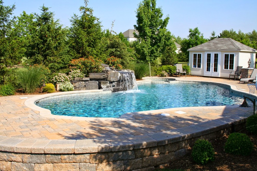 Ejemplo de piscinas y jacuzzis alargados clásicos renovados extra grandes a medida en patio trasero con adoquines de ladrillo