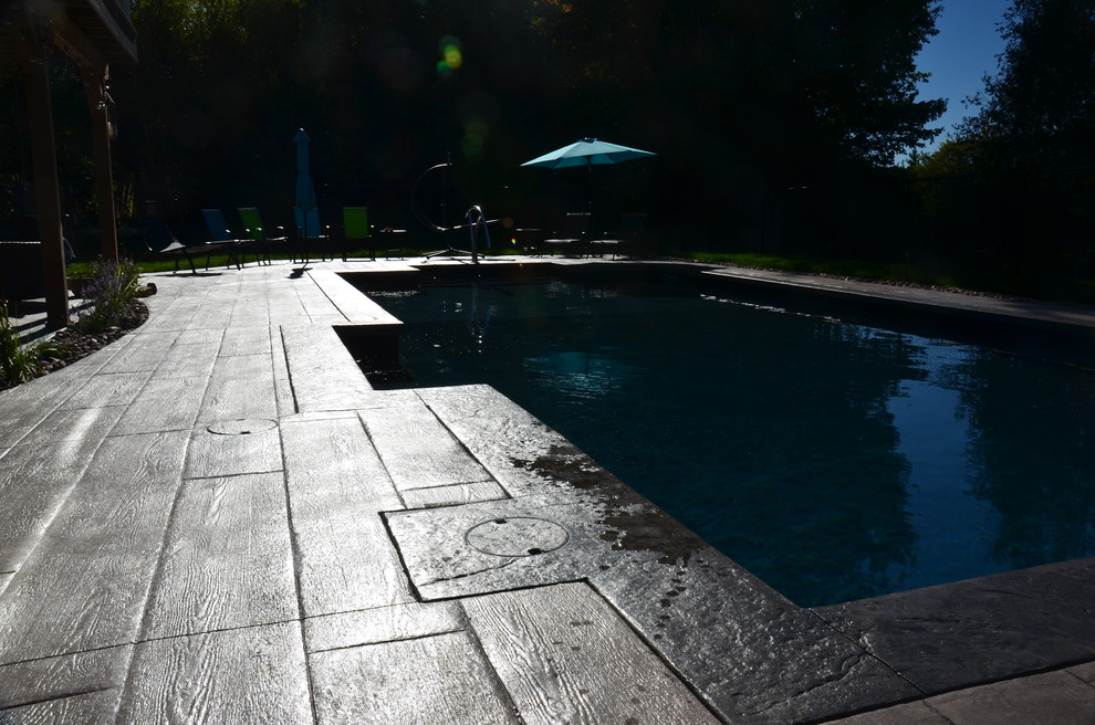 Foto de piscina de estilo americano con suelo de hormigón estampado