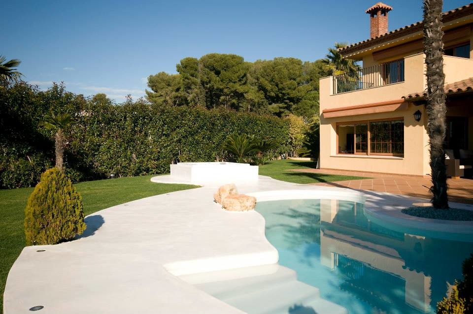 Imagen de piscina natural campestre de tamaño medio tipo riñón en patio trasero con losas de hormigón