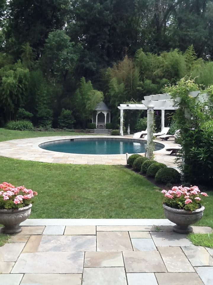 Inspiration för en mellanstor vintage rund pool på baksidan av huset, med marksten i betong
