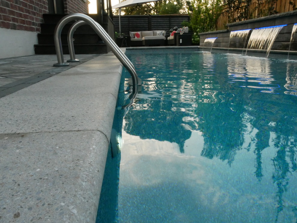 Kleiner Klassischer Schwimmteich hinter dem Haus in rechteckiger Form mit Wasserspiel in Toronto