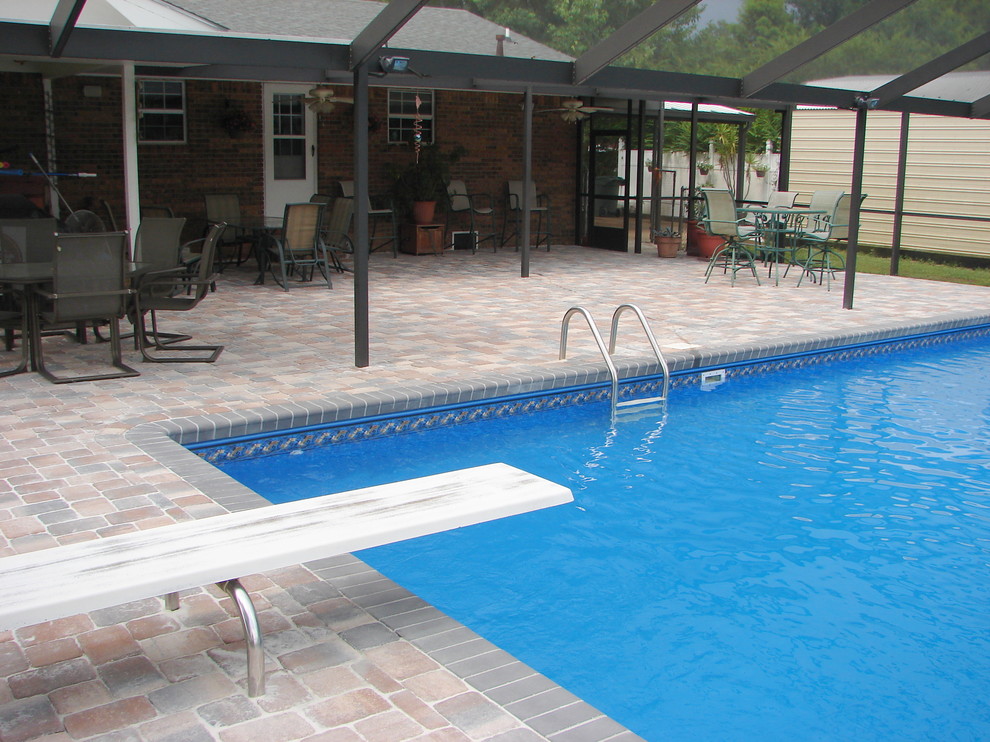 Foto de piscina clásica pequeña rectangular en patio trasero con adoquines de ladrillo
