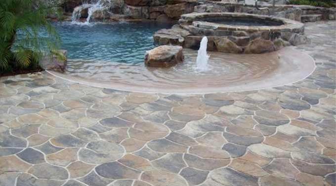 Foto di una piscina moderna personalizzata di medie dimensioni e dietro casa con una vasca idromassaggio e pavimentazioni in pietra naturale