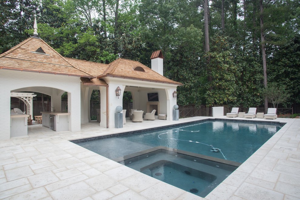 Ejemplo de piscinas y jacuzzis alargados clásicos grandes rectangulares en patio trasero con adoquines de piedra natural