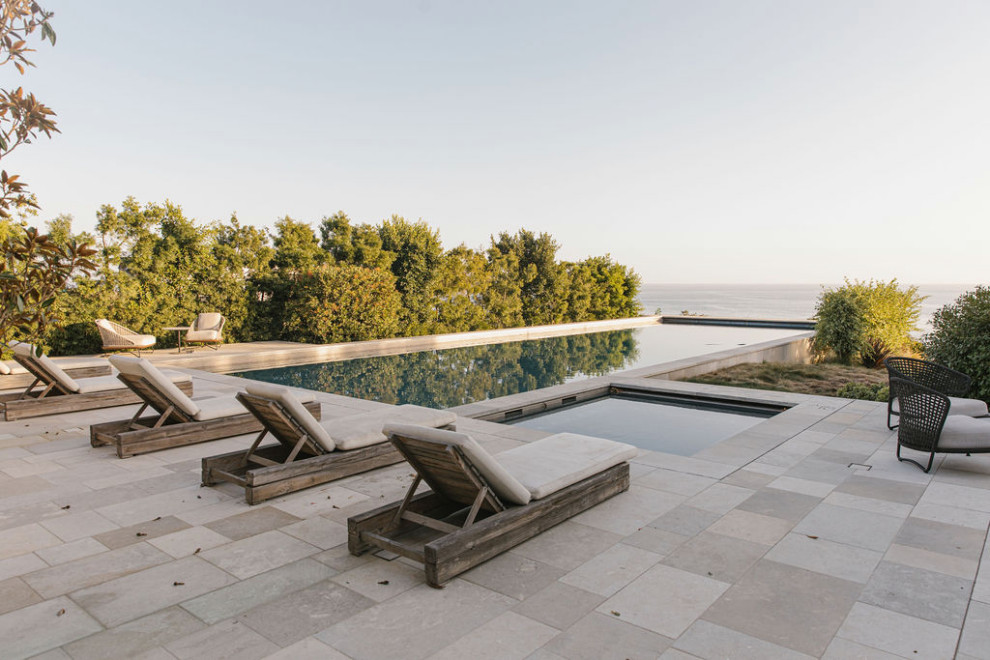 Diseño de casa de la piscina y piscina infinita marinera extra grande rectangular en patio trasero con adoquines de hormigón