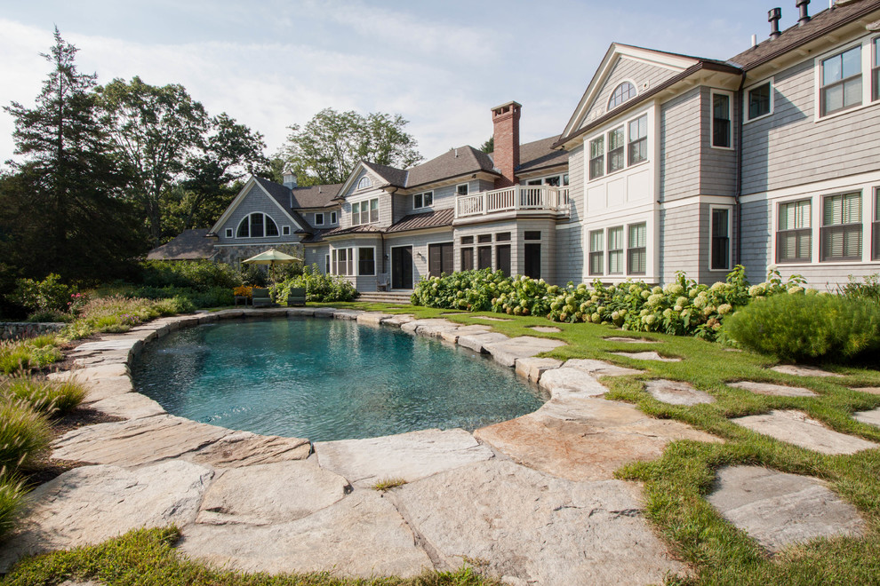 Foto de piscina clásica redondeada con adoquines de piedra natural