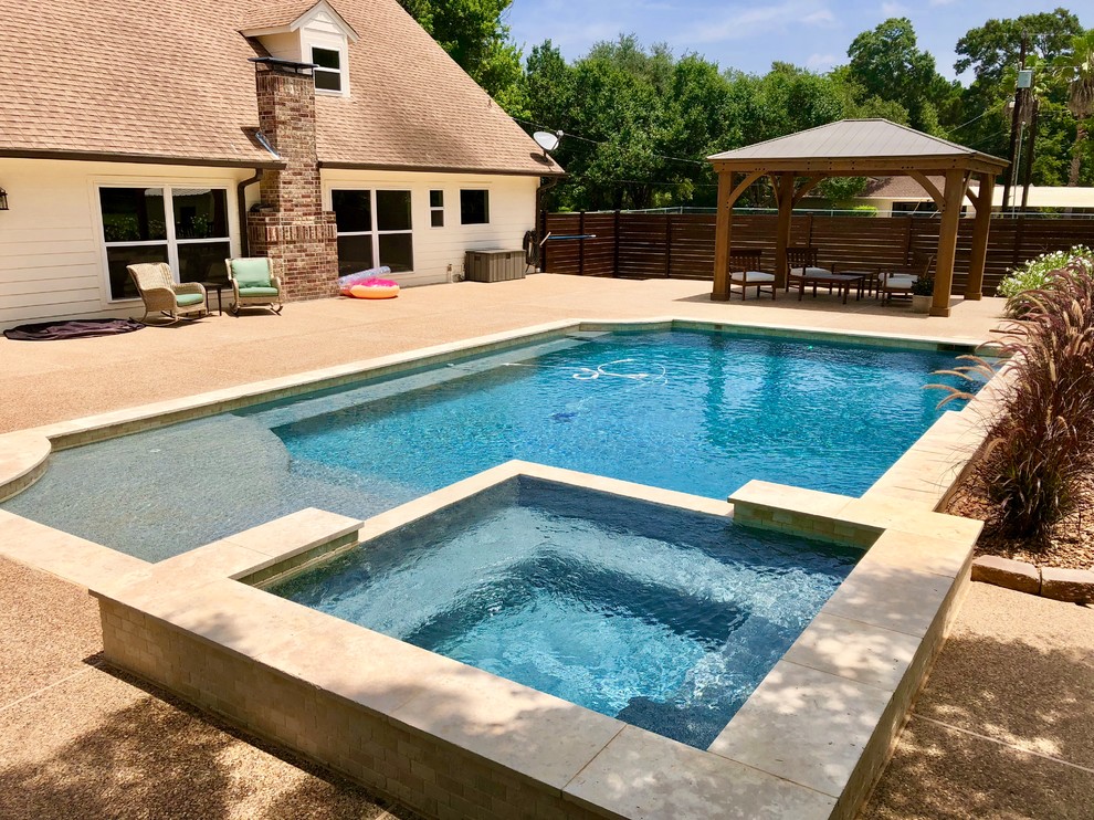 Esempio di una piscina chic rettangolare di medie dimensioni e dietro casa con una vasca idromassaggio e pavimentazioni in cemento