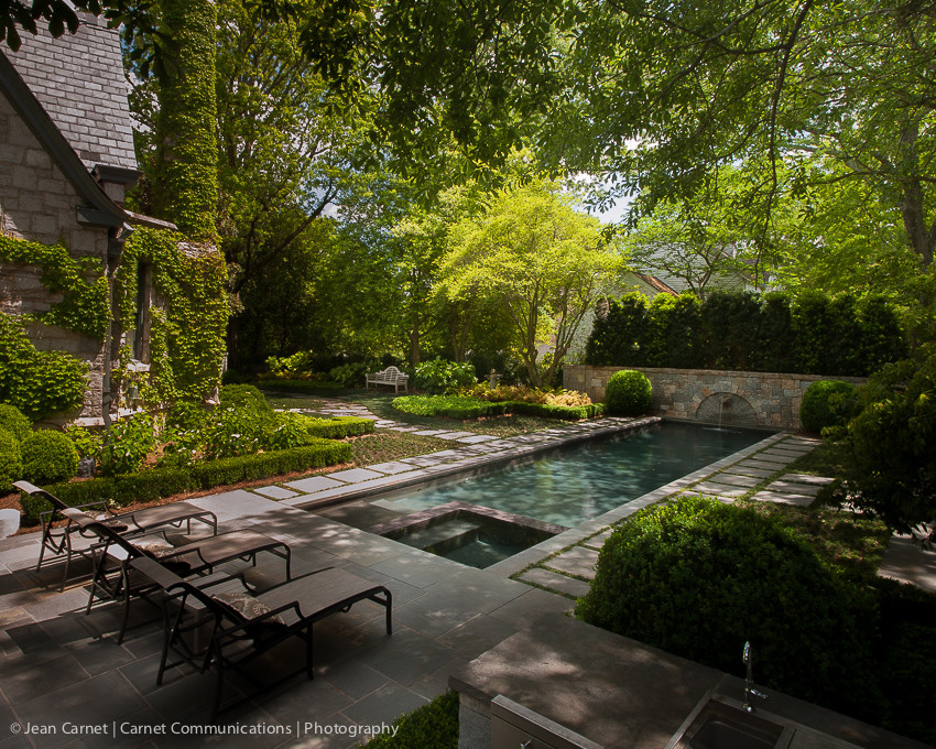 Ejemplo de piscina con fuente alargada contemporánea grande rectangular en patio trasero con adoquines de piedra natural