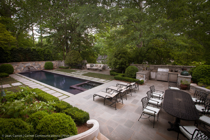 Foto de piscina con fuente alargada tradicional grande rectangular en patio trasero con adoquines de piedra natural