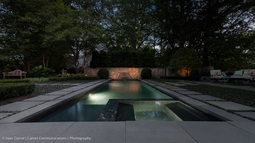 Diseño de piscina con fuente alargada costera grande rectangular en patio trasero con adoquines de piedra natural