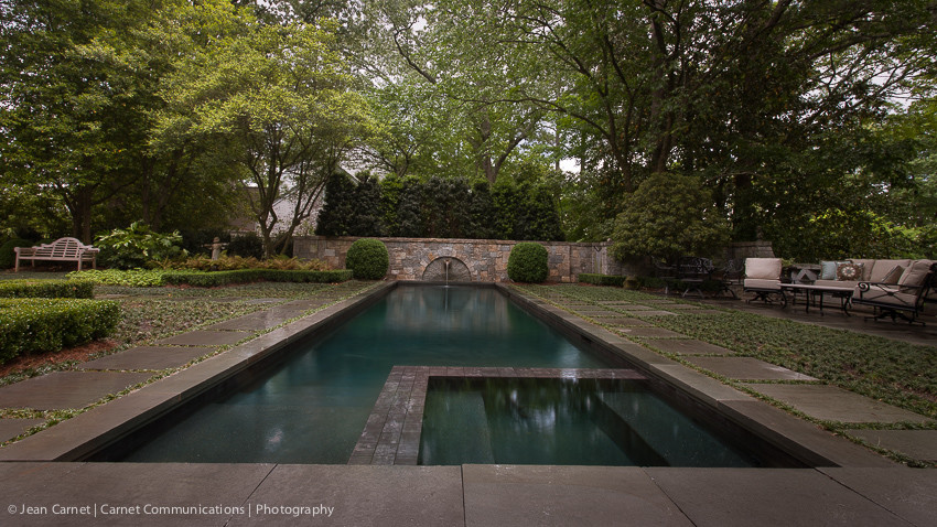 Imagen de piscina con fuente alargada retro grande rectangular en patio trasero con adoquines de piedra natural