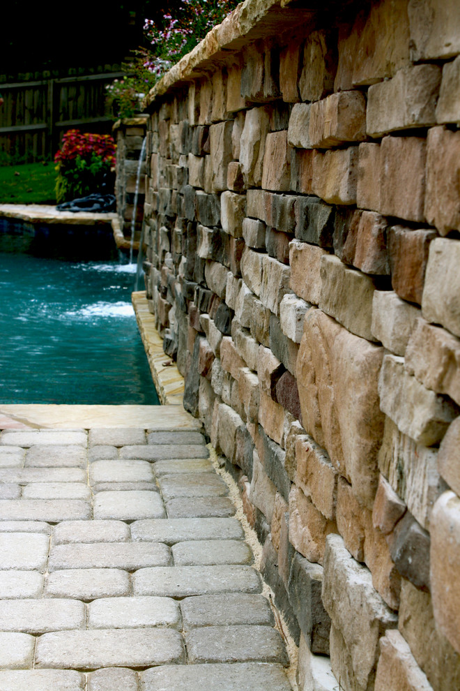 Example of a mid-sized classic backyard stone and custom-shaped natural hot tub design in Atlanta