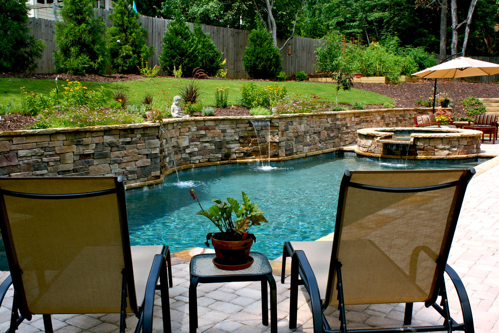 This is an example of a medium sized classic back custom shaped natural hot tub in Atlanta with natural stone paving.