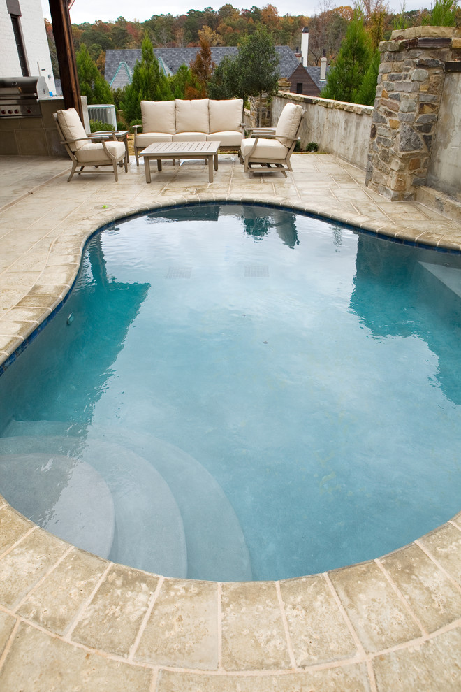 Diseño de piscina clásica renovada pequeña a medida en patio trasero con adoquines de hormigón