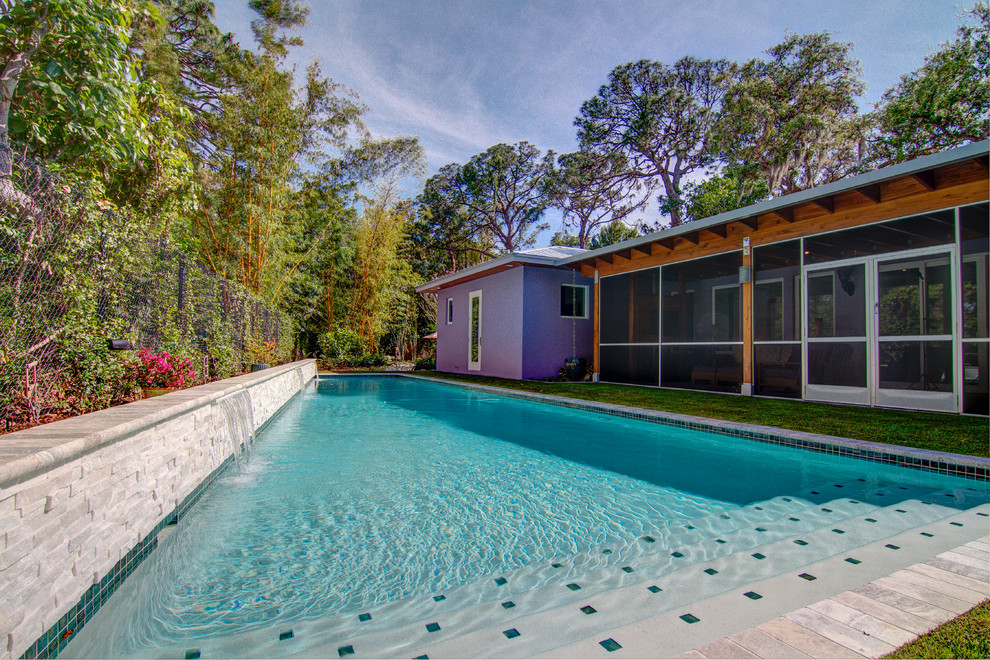 Diseño de piscina con fuente alargada contemporánea grande a medida en patio