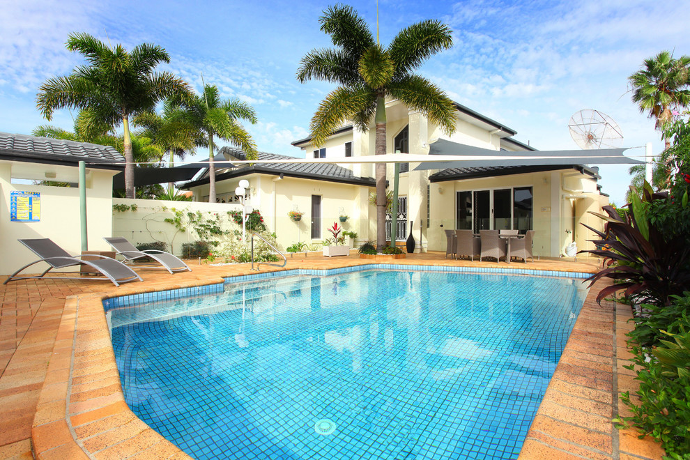 Large beach style front yard brick and rectangular pool photo in Gold Coast - Tweed