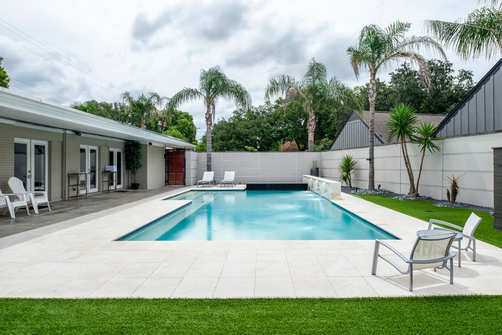 Imagen de piscinas y jacuzzis actuales rectangulares en patio trasero con losas de hormigón