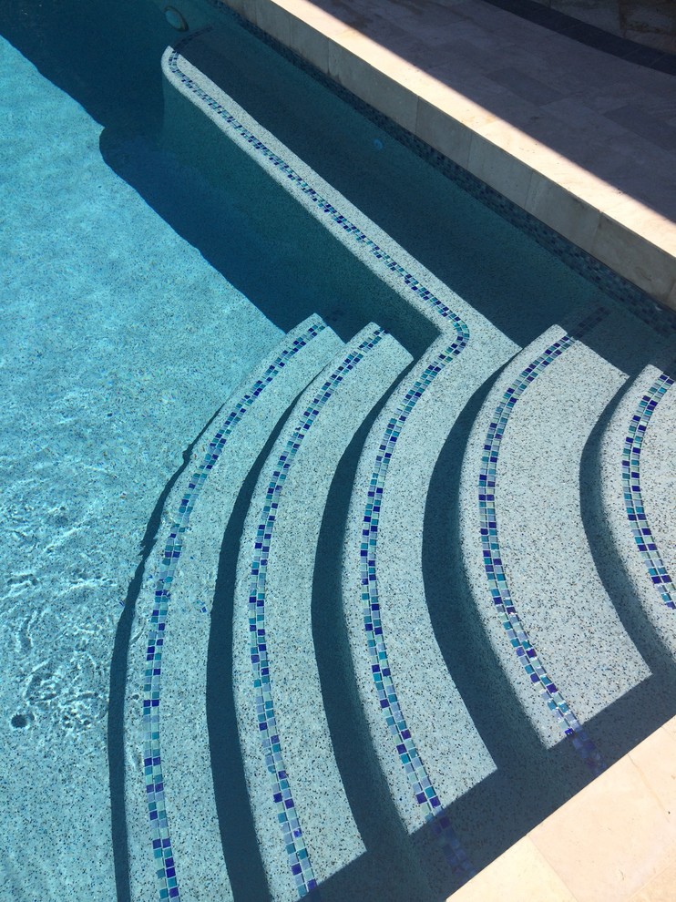 Foto de piscina alargada clásica renovada grande rectangular en patio trasero con suelo de baldosas