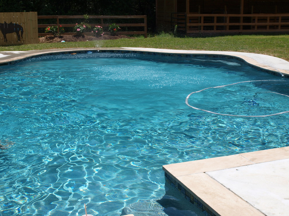 Ispirazione per una grande piscina stile marino personalizzata dietro casa con lastre di cemento