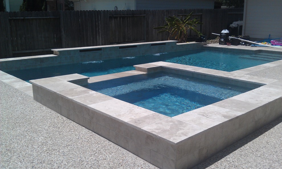 Ejemplo de piscinas y jacuzzis actuales de tamaño medio rectangulares en patio trasero con gravilla