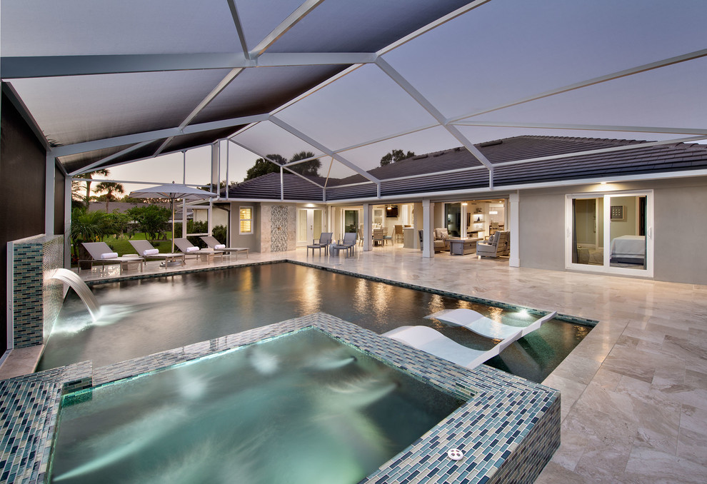 Mittelgroßer, Gefliester Mediterraner Pool hinter dem Haus in rechteckiger Form mit Wasserspiel in Miami