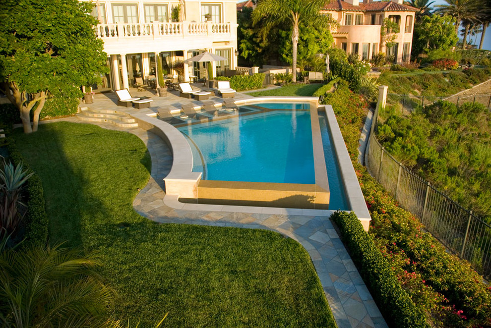 Imagen de piscina contemporánea a medida en patio trasero con adoquines de piedra natural