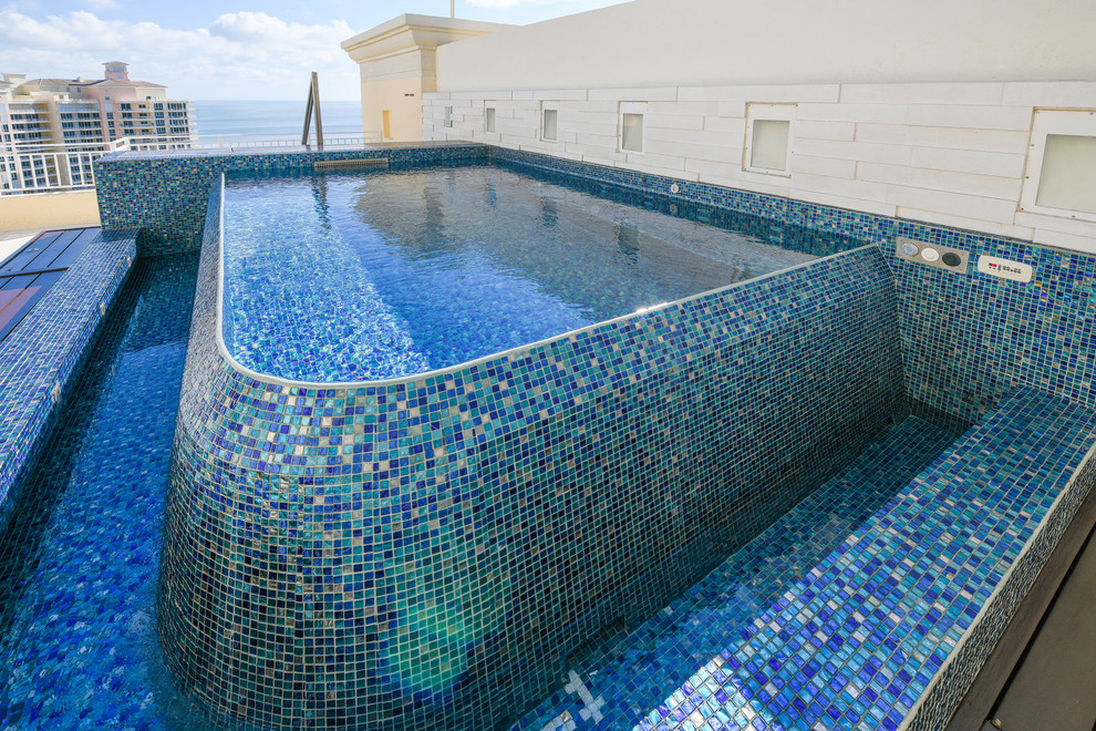 Idée de décoration pour une petite piscine sur toit à débordement méditerranéenne rectangle avec un bain bouillonnant et des pavés en pierre naturelle.