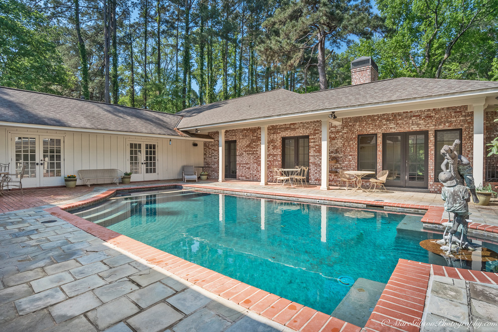 Esempio di una piscina naturale classica rettangolare di medie dimensioni e in cortile con una vasca idromassaggio e pavimentazioni in pietra naturale