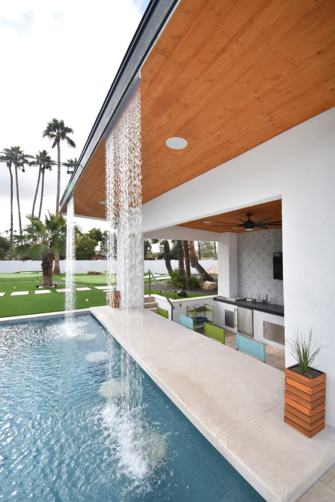 Exemple d'une grande piscine arrière moderne sur mesure avec des pavés en pierre naturelle.