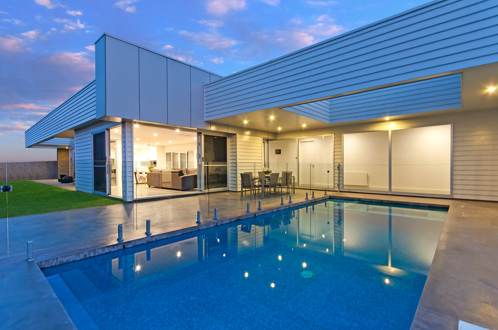 Ispirazione per una grande piscina monocorsia moderna rettangolare dietro casa con pavimentazioni in cemento