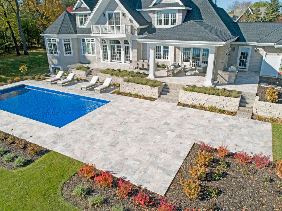 Imagen de casa de la piscina y piscina costera rectangular en patio trasero con adoquines de piedra natural