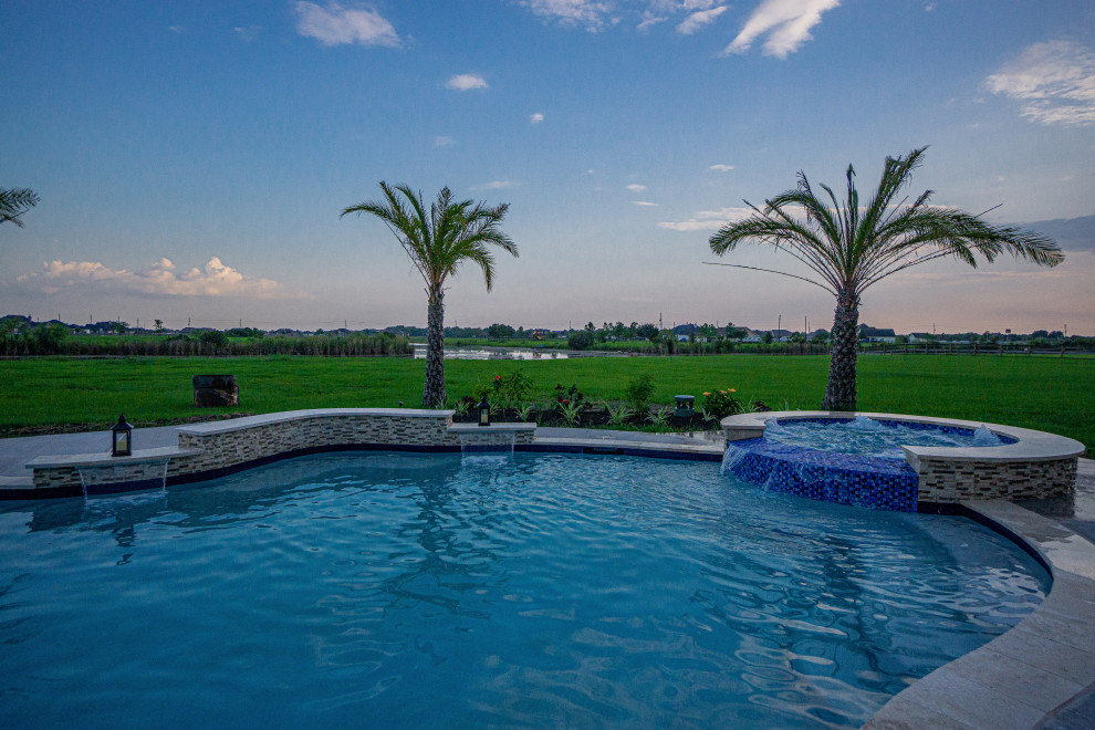 Immagine di una piscina tropicale personalizzata di medie dimensioni e dietro casa