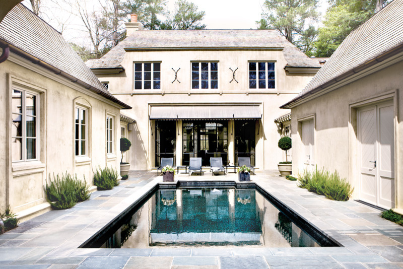 Diseño de piscina alargada tradicional grande rectangular en patio con adoquines de piedra natural
