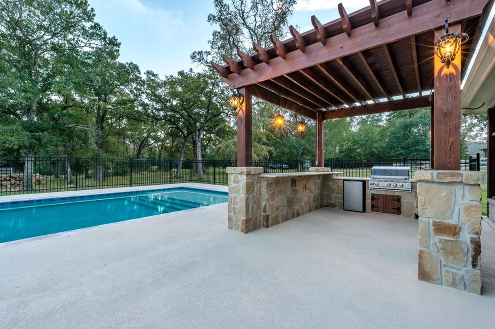 Ejemplo de piscina con fuente alargada moderna grande a medida en patio trasero con entablado