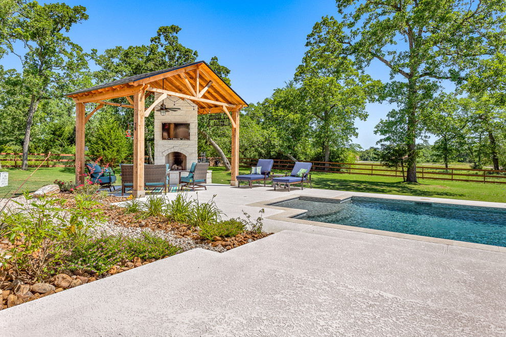 Immagine di una piscina naturale rustica personalizzata di medie dimensioni e dietro casa con lastre di cemento