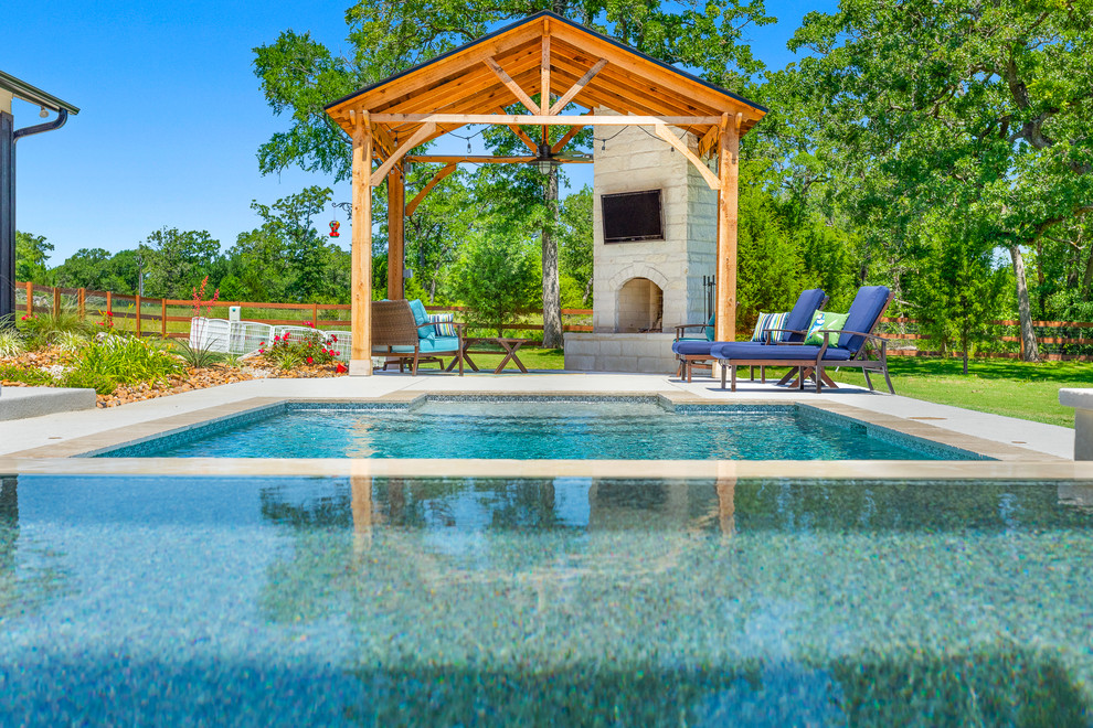 Пример оригинального дизайна: естественный бассейн среднего размера, произвольной формы на заднем дворе в стиле рустика с покрытием из бетонных плит