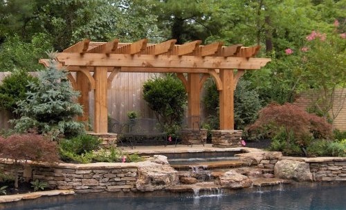 Foto de piscinas y jacuzzis naturales clásicos de tamaño medio a medida en patio trasero con adoquines de piedra natural