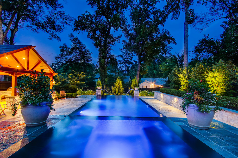 На фото: большой прямоугольный бассейн-инфинити на заднем дворе в классическом стиле с джакузи и покрытием из каменной брусчатки с
