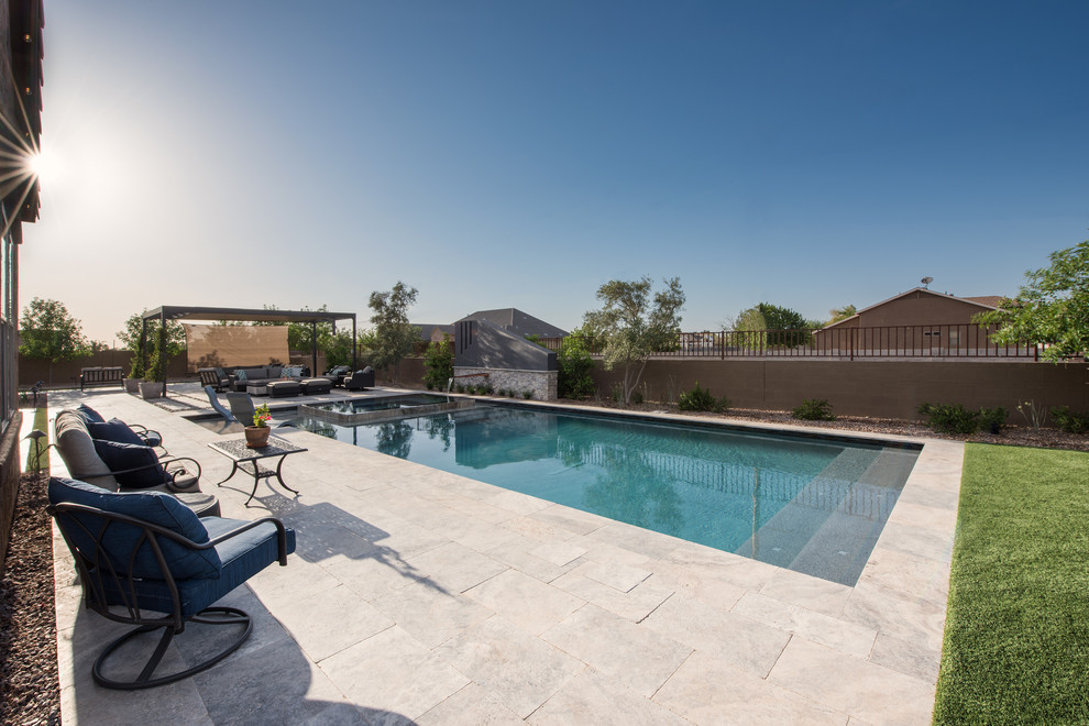 Mid-sized minimalist backyard stone and rectangular infinity pool photo in Phoenix