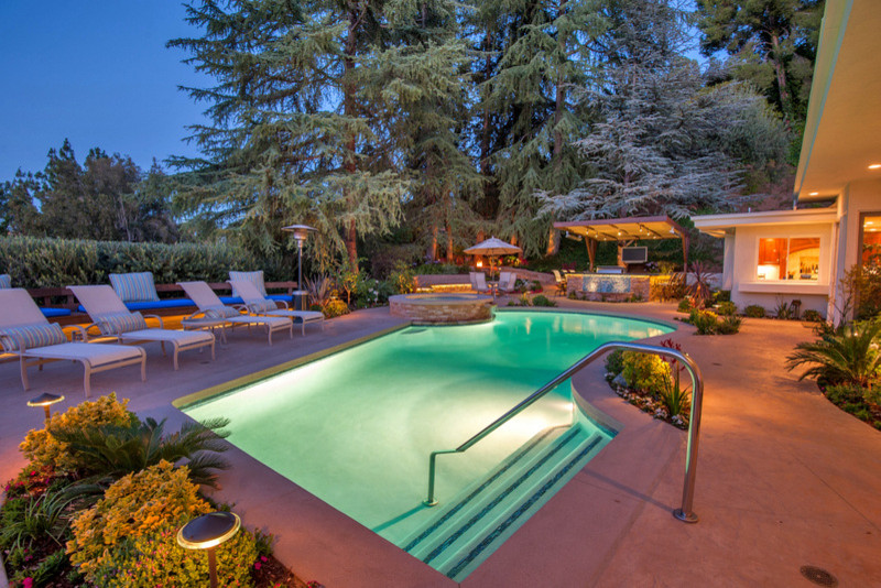 Großer Moderner Pool hinter dem Haus in individueller Form mit Betonplatten in Los Angeles