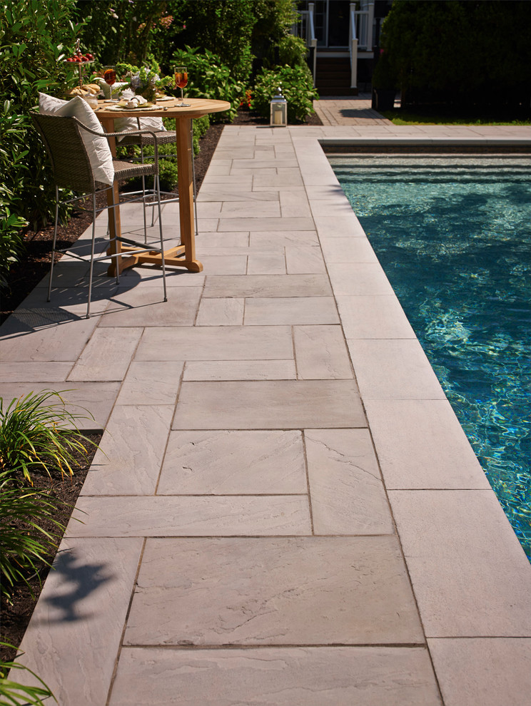 Modelo de piscina con fuente natural clásica renovada pequeña rectangular en patio trasero con adoquines de piedra natural